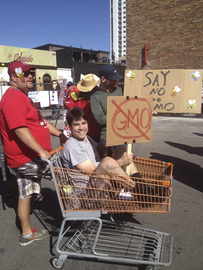 Dale Andriaansen pushes Andrew Russell in a shopping cart at the anti-GMO/Monsanto march in downtown Las Vegas on Saturday, Oct. 12, 2013.